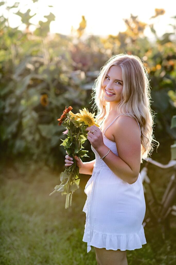 Smiling blonde haired teen holding a bouquet of flowers in a garden in Middletown, Maryland.