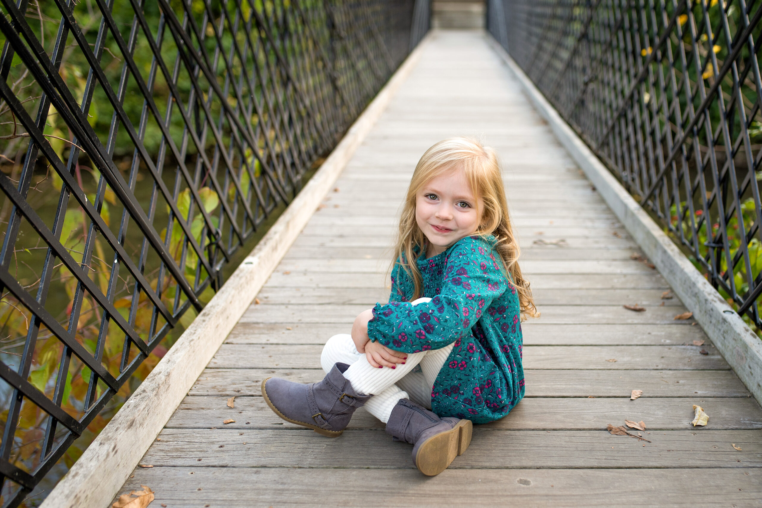 Toddler girl smiling on a bridge in Baker Park in Frederick, MD.